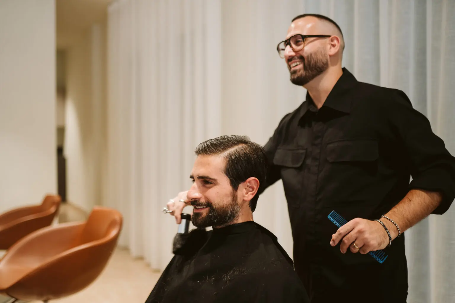 Andrea sorride mentre lavora con una persona nel salone Rêves